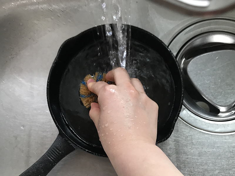 使用後の鉄スキレットをお湯とタワシで洗う
