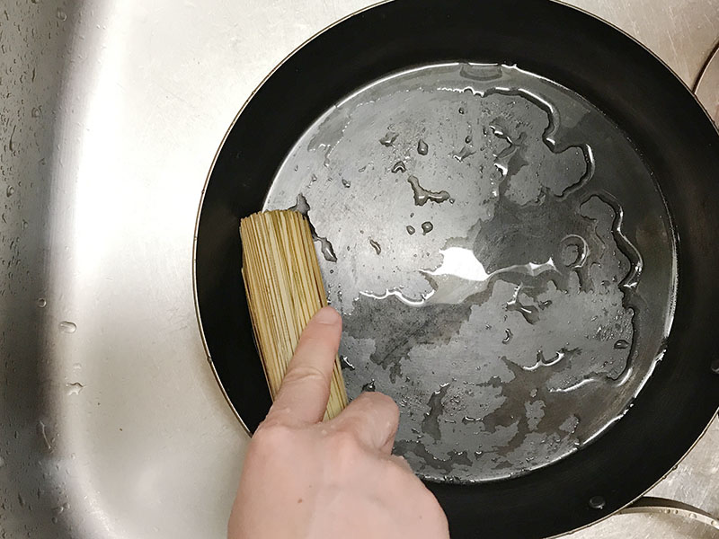 鉄フライパンのスミをささらで洗う